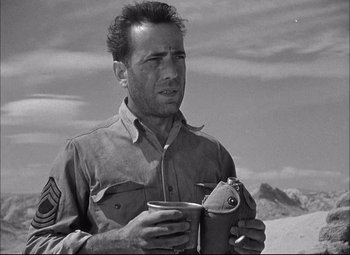 Movie still from “Sahara” (1943), directed by Zoltan Korda – A man holding a cup in his hands; Close Up shot, Low angle