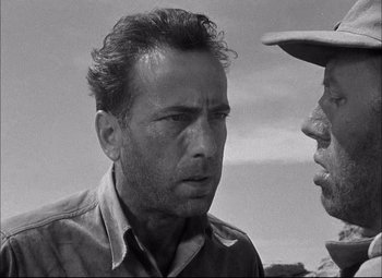 Movie still from “Sahara” (1943), directed by Zoltan Korda – A black - and - white photo of a man talking to another man; Close Up shot, Low angle
