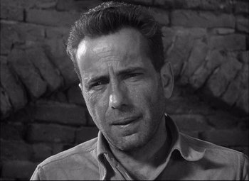 Movie still from “Sahara” (1943), directed by Zoltan Korda – Black and white photograph of a man with a sad look; Close Up shot, Low angle