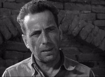 Movie still from “Sahara” (1943), directed by Zoltan Korda – Black and white photograph of a man in a shirt; Close Up shot, Low angle