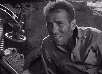 Movie still from “Sahara” (1943), directed by Zoltan Korda – Black and white photograph of a man smiling; Close Up shot, Over the shoulder angle