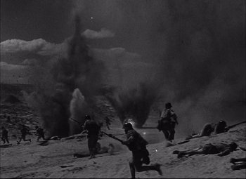 Movie still from “Sahara” (1943), directed by Zoltan Korda – A black and white photo of soldiers in action; Extreme Wide shot, High angle
