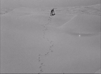 Movie still from “Sahara” (1943), directed by Zoltan Korda – A person riding skis on a snowy slope; Extreme Wide shot, High angle