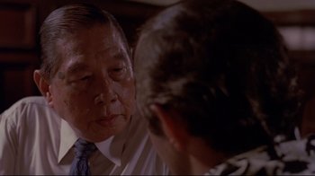 Movie still from “Saint Jack” (1979), directed by Peter Bogdanovich – An older man and a younger man are talking to each other; Close Up shot, Over the shoulder angle