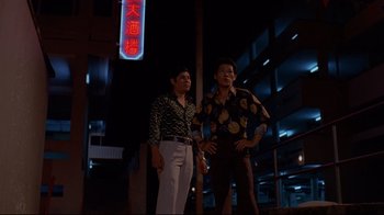 Movie still from “Saint Jack” (1979), directed by Peter Bogdanovich – A couple of men standing next to each other on the street; Wide shot, Low angle