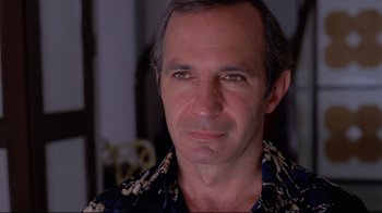 Movie still from “Saint Jack” (1979), directed by Peter Bogdanovich – A person wearing a floral shirt; Close Up shot, Low angle