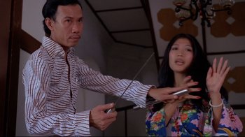 Movie still from “Saint Jack” (1979), directed by Peter Bogdanovich – A man and a woman playing a video game together; Medium shot, Low angle