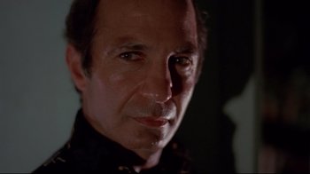 Movie still from “Saint Jack” (1979), directed by Peter Bogdanovich – A person wearing a black shirt; Close Up shot, Low angle