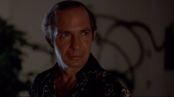 Movie still from “Saint Jack” (1979), directed by Peter Bogdanovich – A person wearing a black shirt; Close Up shot, Low angle