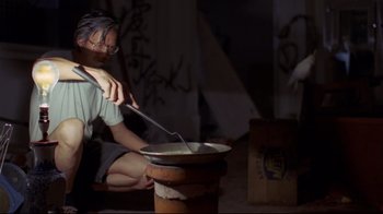 Movie still from “Saint Jack” (1979), directed by Peter Bogdanovich – A person sitting in front of a pot of food; Medium shot, Low angle