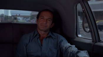 Movie still from “Saint Jack” (1979), directed by Peter Bogdanovich – A man sitting in the back seat of a car; Close Up shot, Low angle