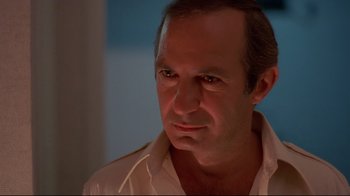 Movie still from “Saint Jack” (1979), directed by Peter Bogdanovich – A person wearing a white shirt; Close Up shot, Low angle