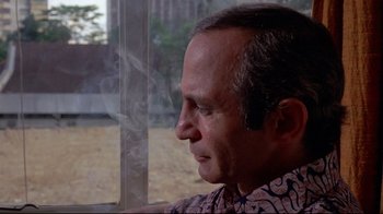 Movie still from “Saint Jack” (1979), directed by Peter Bogdanovich – A person looking out of a window; Close Up shot, Low angle