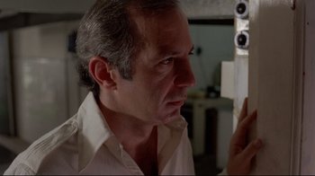 Movie still from “Saint Jack” (1979), directed by Peter Bogdanovich – A person looking at a mirror; Close Up shot, Low angle