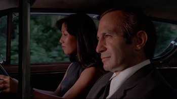 Movie still from “Saint Jack” (1979), directed by Peter Bogdanovich – A man and a woman sitting in the back of a car; Close Up shot, Low angle
