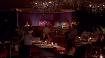 Movie still from “Saint Jack” (1979), directed by Peter Bogdanovich – A group of people sitting at tables in a restaurant; Extreme Wide shot, High angle