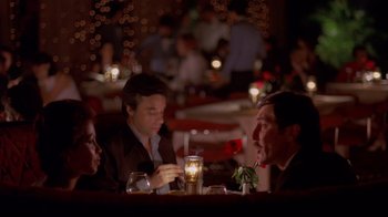 Movie still from “Saint Jack” (1979), directed by Peter Bogdanovich – A group of people sitting at a table in a restaurant; Medium shot, High angle