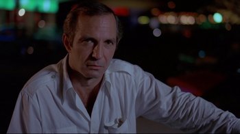 Movie still from “Saint Jack” (1979), directed by Peter Bogdanovich – A person wearing a white dress shirt; Close Up shot, Low angle