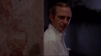 Movie still from “Saint Jack” (1979), directed by Peter Bogdanovich – A person standing next to a wall; Close Up shot, Low angle