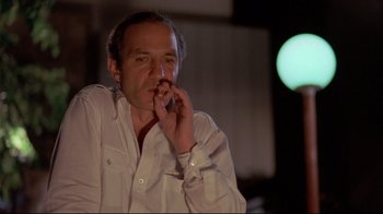Movie still from “Saint Jack” (1979), directed by Peter Bogdanovich – A man in a white shirt is smoking a cigarette; Close Up shot, Low angle