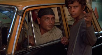 Movie still from “Salaam Bombay!” (1988), directed by Mira Nair – Two young men are looking in the mirror of a taxi; Close Up shot, Low angle