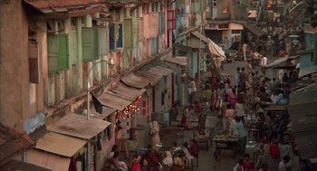 Movie still from “Salaam Bombay!” (1988), directed by Mira Nair – An overhead view of a street with people walking around it; Extreme Wide shot, High angle