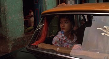 Movie still from “Salaam Bombay!” (1988), directed by Mira Nair – A woman sitting in the passenger seat of a car; Close Up shot, High angle
