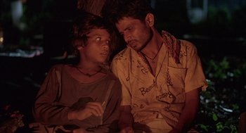 Movie still from “Salaam Bombay!” (1988), directed by Mira Nair – A man and a woman sitting next to each other; Close Up shot, High angle