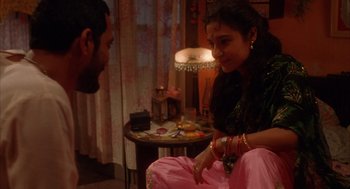 Movie still from “Salaam Bombay!” (1988), directed by Mira Nair – A man and a woman sitting in a living room talking; Medium shot, High angle