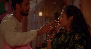 Movie still from “Salaam Bombay!” (1988), directed by Mira Nair – A man and a woman are smoking a cigarette together; Close Up shot, Over the shoulder angle