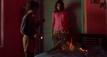 Movie still from “Salaam Bombay!” (1988), directed by Mira Nair – Two people standing in front of a fire pit; Medium shot, High angle