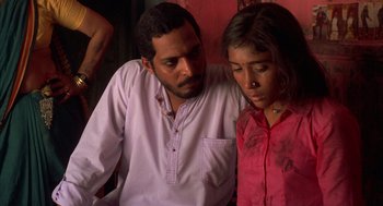 Movie still from “Salaam Bombay!” (1988), directed by Mira Nair – A man and a woman sitting next to each other; Close Up shot, Low angle