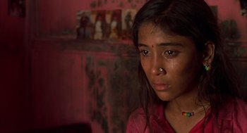 Movie still from “Salaam Bombay!” (1988), directed by Mira Nair – A woman with a nose ring looking at the camera; Close Up shot, High angle