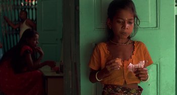 Movie still from “Salaam Bombay!” (1988), directed by Mira Nair – A young girl standing next to a door; Close Up shot, High angle