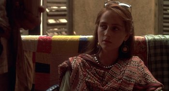 Movie still from “Salaam Bombay!” (1988), directed by Mira Nair – A woman sitting in a chair wearing a colorful outfit; Close Up shot, Over the shoulder angle