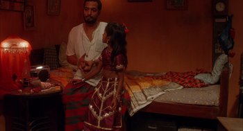 Movie still from “Salaam Bombay!” (1988), directed by Mira Nair – A man and a little girl standing next to each other; Medium shot, High angle