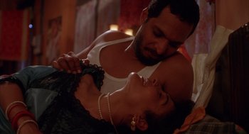 Movie still from “Salaam Bombay!” (1988), directed by Mira Nair – A man and a woman are in a room; Close Up shot, Overhead angle