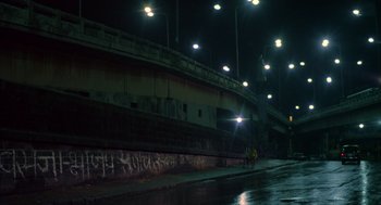 Movie still from “Salaam Bombay!” (1988), directed by Mira Nair – A bridge lit up at night by street lights; Extreme Wide shot, Low angle