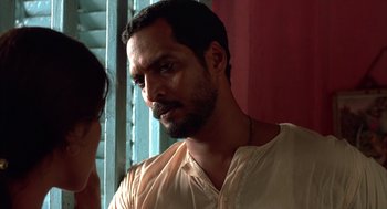 Movie still from “Salaam Bombay!” (1988), directed by Mira Nair – A person wearing a white shirt; Close Up shot, Over the shoulder angle
