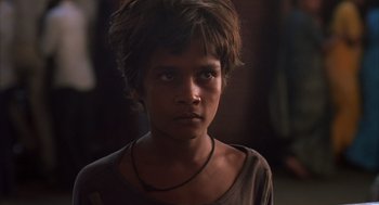 Movie still from “Salaam Bombay!” (1988), directed by Mira Nair – A young boy is looking at the camera; Close Up shot, High angle