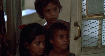 Movie still from “Salaam Bombay!” (1988), directed by Mira Nair – A group of young children standing next to a door; Close Up shot, High angle