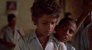 Movie still from “Salaam Bombay!” (1988), directed by Mira Nair – Two young boys standing next to each other in a room; Close Up shot, Low angle