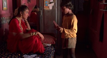 Movie still from “Salaam Bombay!” (1988), directed by Mira Nair – A boy and a girl in a room; Medium shot, High angle