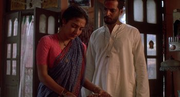 Movie still from “Salaam Bombay!” (1988), directed by Mira Nair – A man and a woman standing next to each other; Medium shot, Low angle