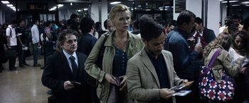 Movie still from “Salt and Fire” (2016), directed by Werner Herzog – A man and a woman standing next to each other in a crowd; Medium shot, Over the shoulder angle