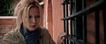 Movie still from “Salt and Fire” (2016), directed by Werner Herzog – A woman leaning on a metal gate; Close Up shot, Over the shoulder angle