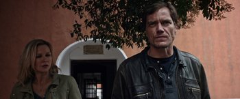 Movie still from “Salt and Fire” (2016), directed by Werner Herzog – A man wearing a leather jacket standing in front of a building; Close Up shot, Low angle