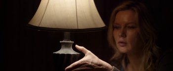 Movie still from “Salt and Fire” (2016), directed by Werner Herzog – A woman holding out her hand near a table lamp; Close Up shot, Over the shoulder angle
