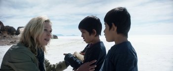 Movie still from “Salt and Fire” (2016), directed by Werner Herzog – A group of young people standing next to each other on a beach; Medium shot, Over the shoulder angle