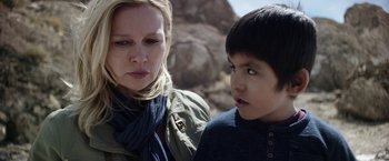 Movie still from “Salt and Fire” (2016), directed by Werner Herzog – A woman standing next to a young boy in front of rocks; Close Up shot, Over the shoulder angle